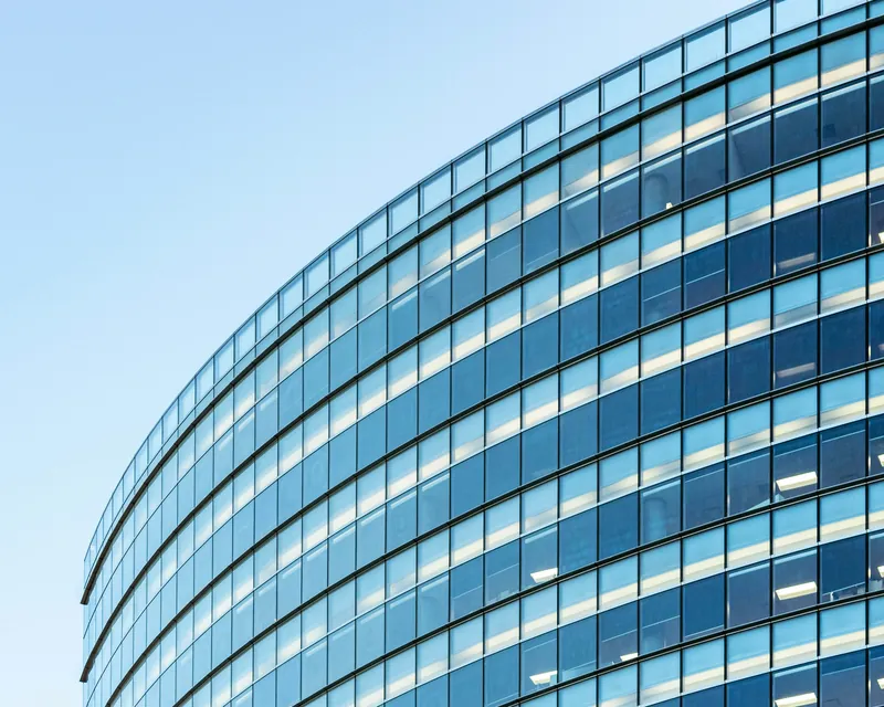 The curved glass facade of a modern office tower